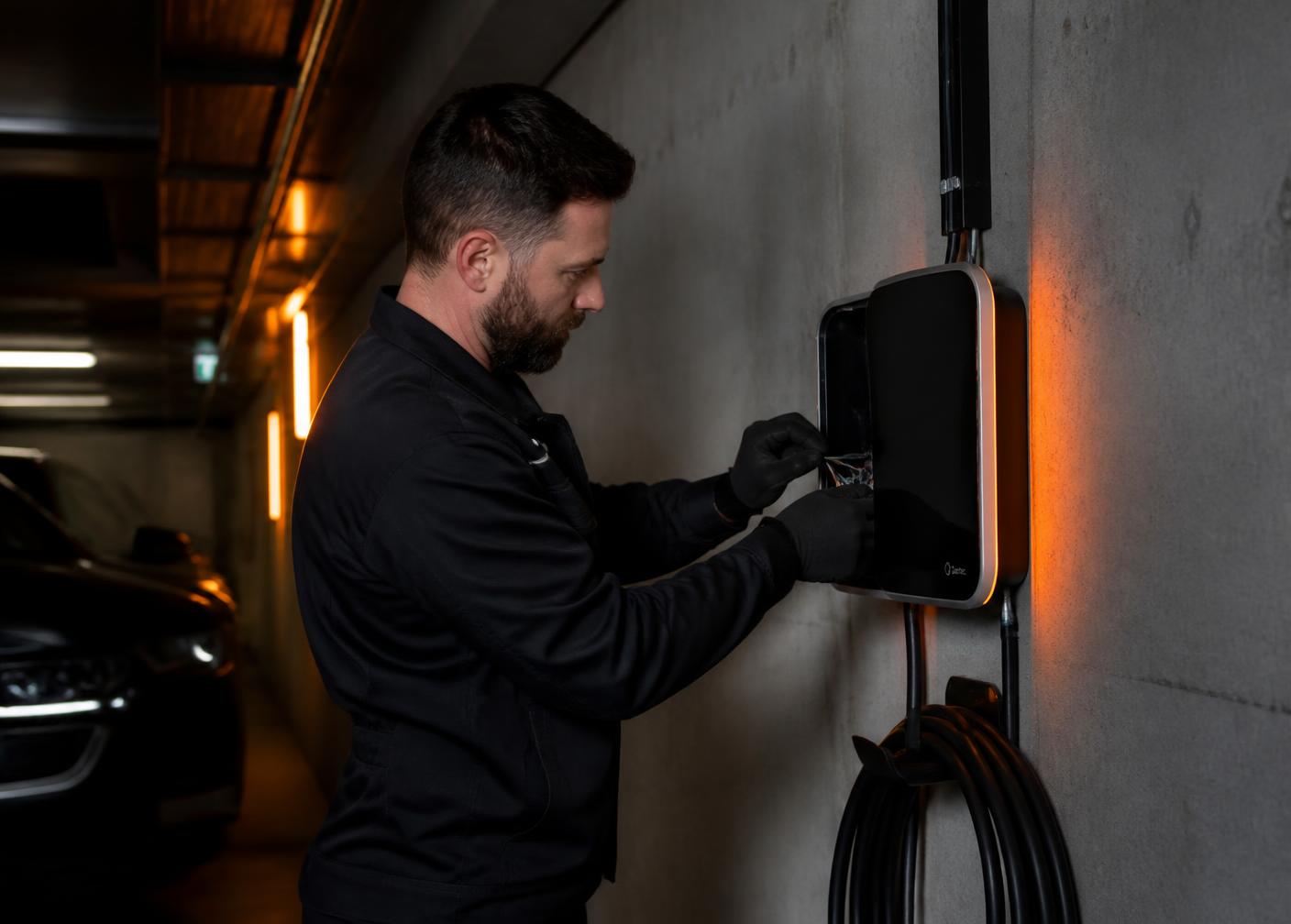 Elektrofachkraft installiert eine Wallbox in einer Tiefgarage